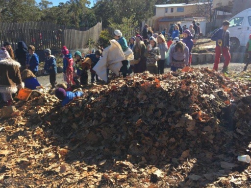 Kindlehill students and families work together building a large biodynamic compost pile from seasonal autumn leaves.