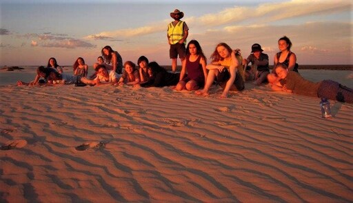 Kindlehill students connect their inner soulscapes to Country while resting on vast, rippled sand dunes at sunset.