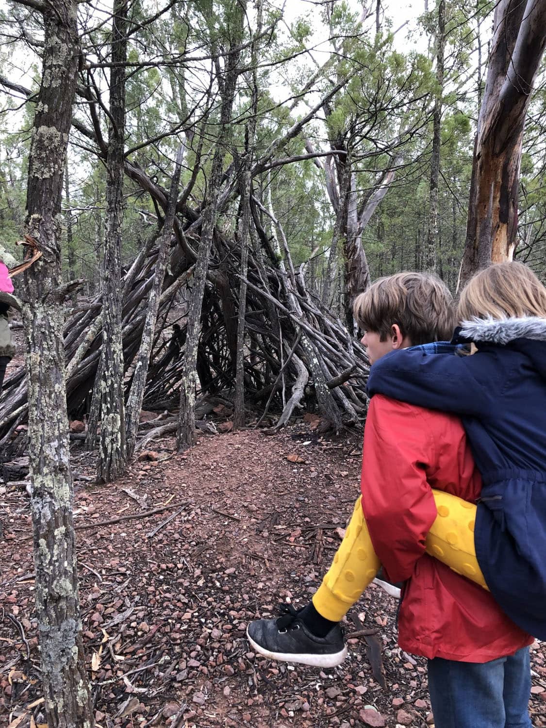 Students demonstrate cooperation and connection to Country beside a bush shelter in the western New South Wales wilderness.