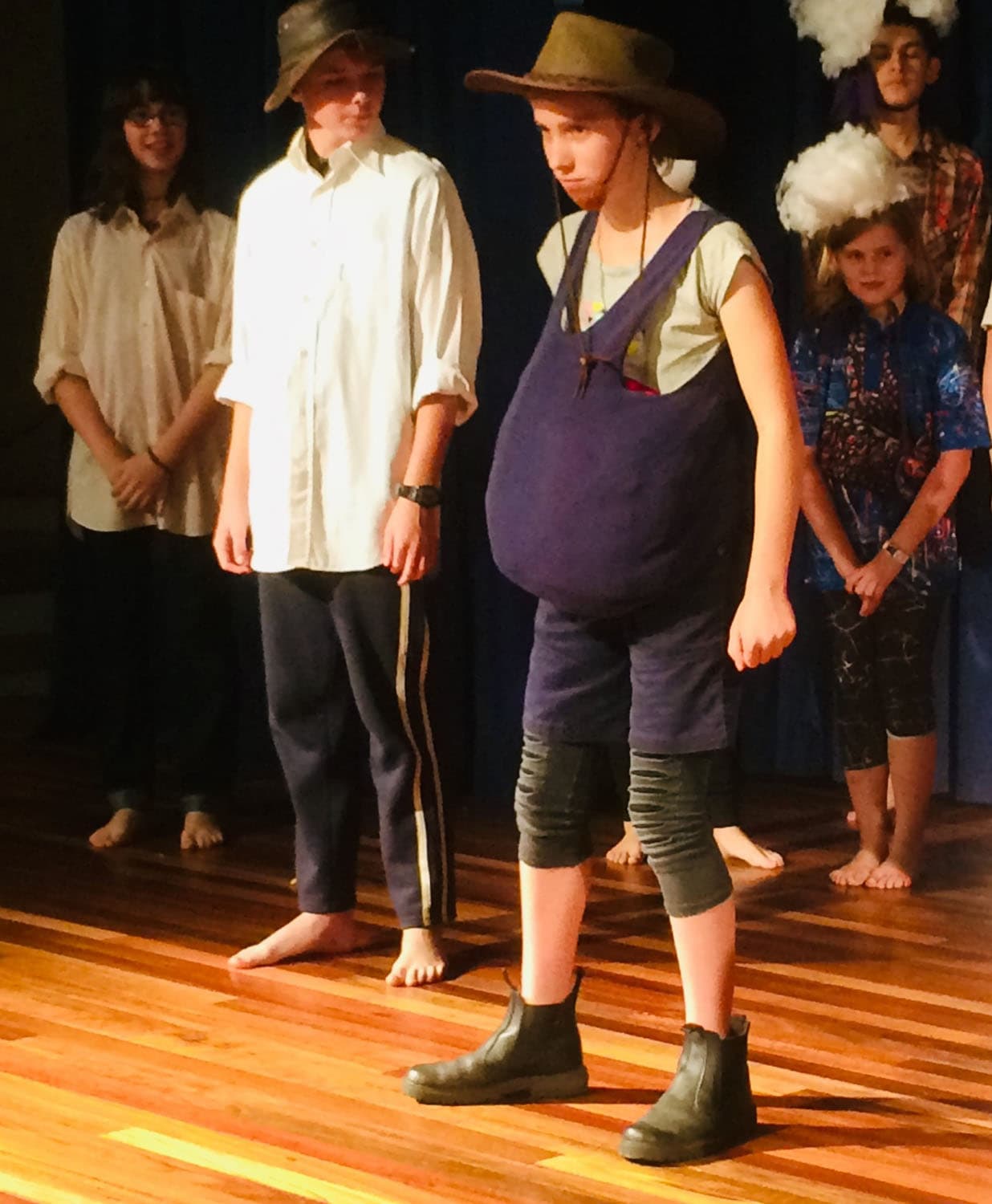 Students perform self-adapted plays on stage, awakening imagination and community spirit through creative storytelling and artistic expression.