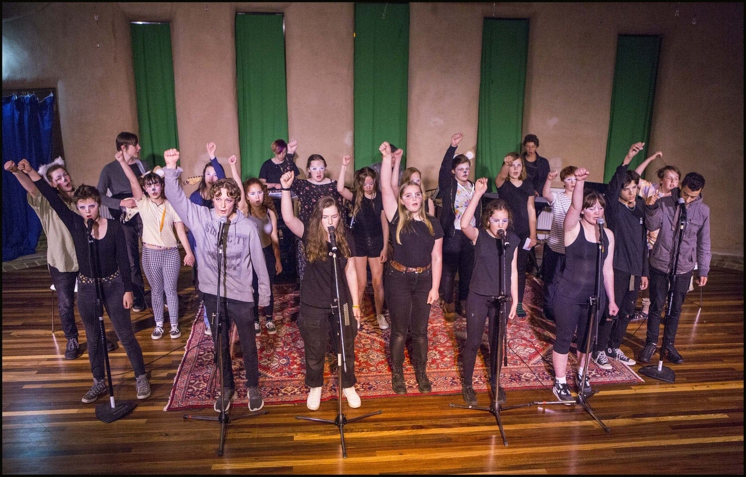 Kindlehill eco-warriors sing with raised fists, honouring our planet through heart, soul, and collaborative artistic expression.