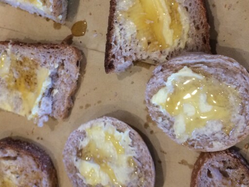 Buttered bread with Kindlehill honey shared during an equinox celebration to nourish community and support social justice.