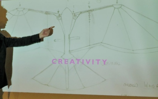 A student points to technical wing sketches, showcasing an individual path where imagination and practical skill honourably converge.