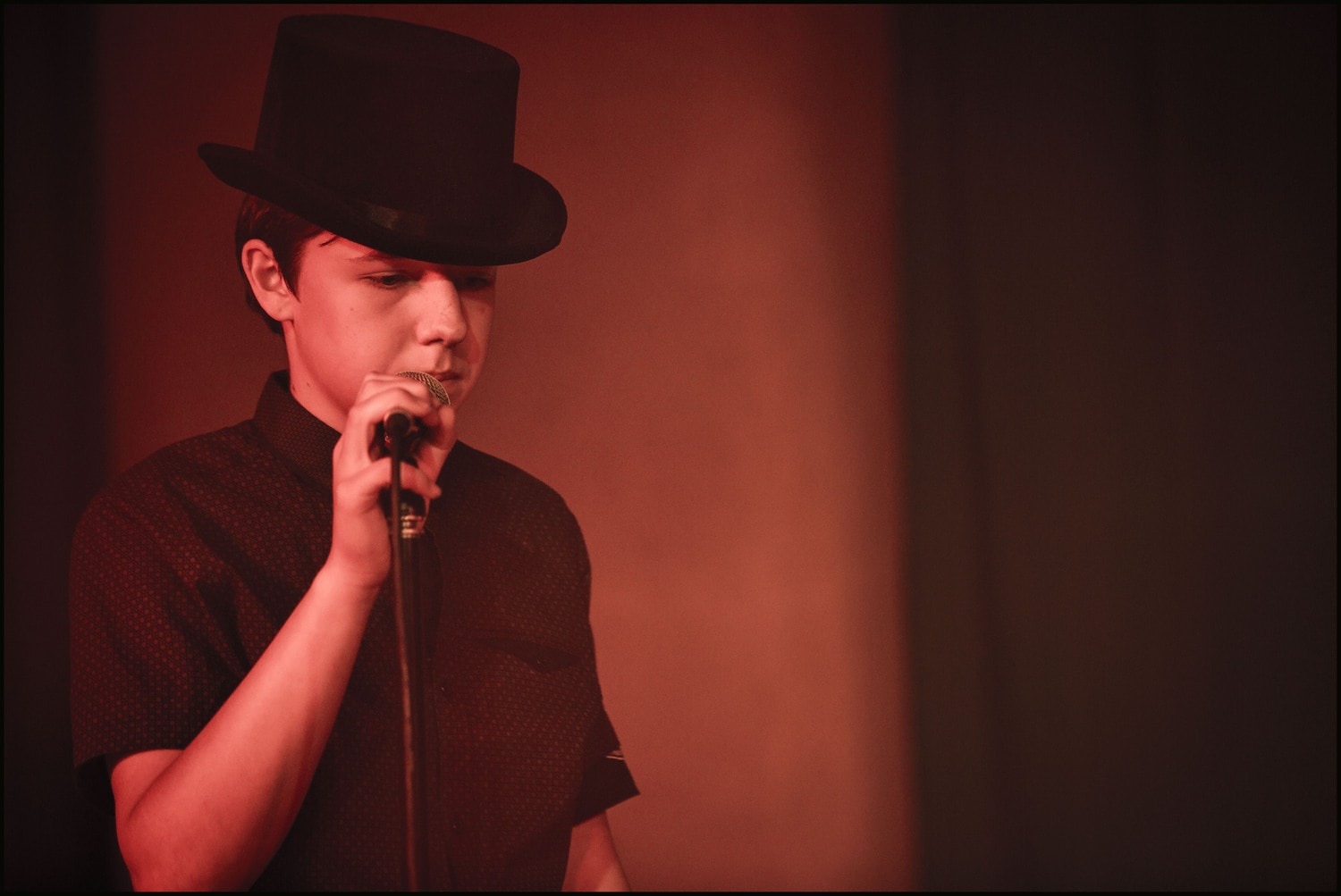 A Kindlehill student performs in a top hat, embodying creative confidence and individual expression within the schools music programme.