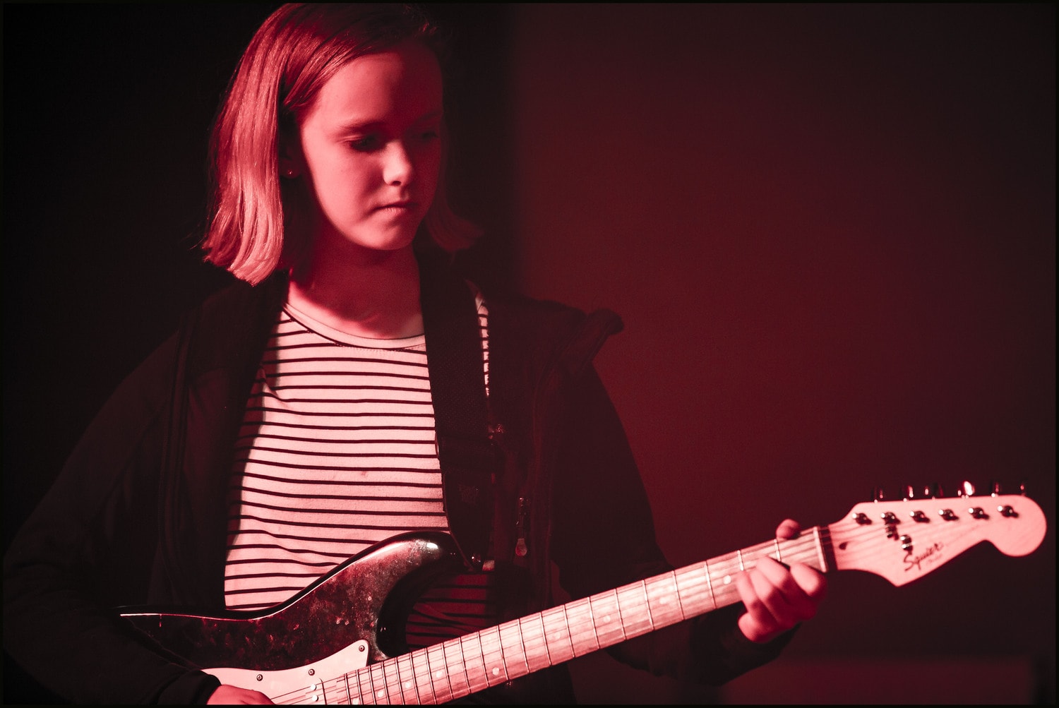 Focused Kindlehill student performs on electric guitar, channelling her artistic expression through the schools inclusive music programme.