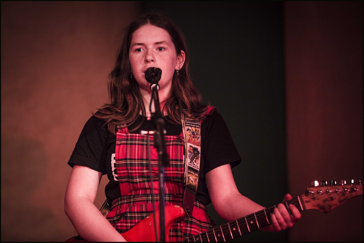 A high school student performs within the inclusive music programme, singing and playing electric guitar at Kindlehill.