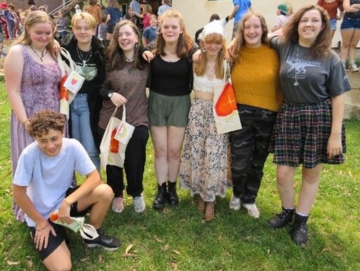 Graduates stand together on the grass, embodying the strong community connection and village spirit cultivated at Kindlehill.