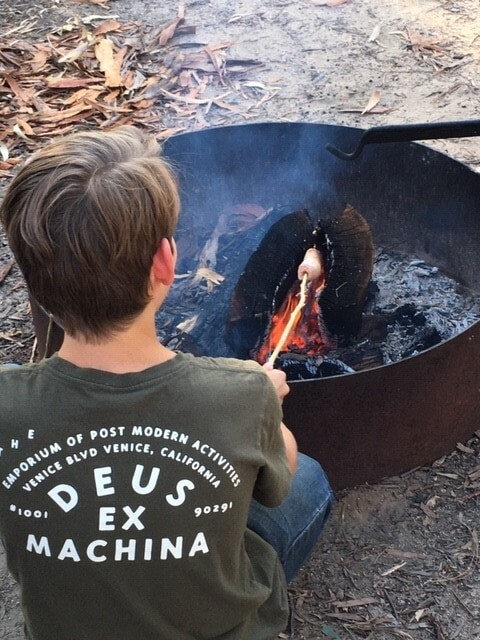 A student toasts damper over a campfire, fostering a deep connection with the land and natures rhythms.