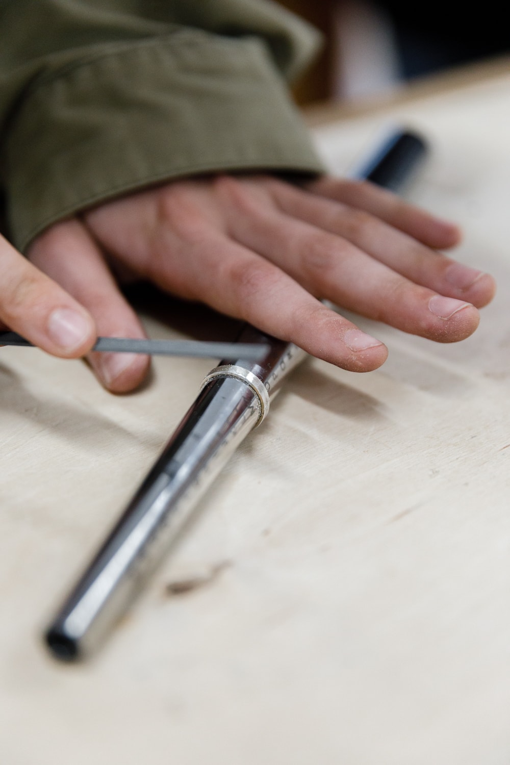 Focused student hands filing a sterling silver ring, connecting head, heart, and hands through technical metalwork and craftsmanship.