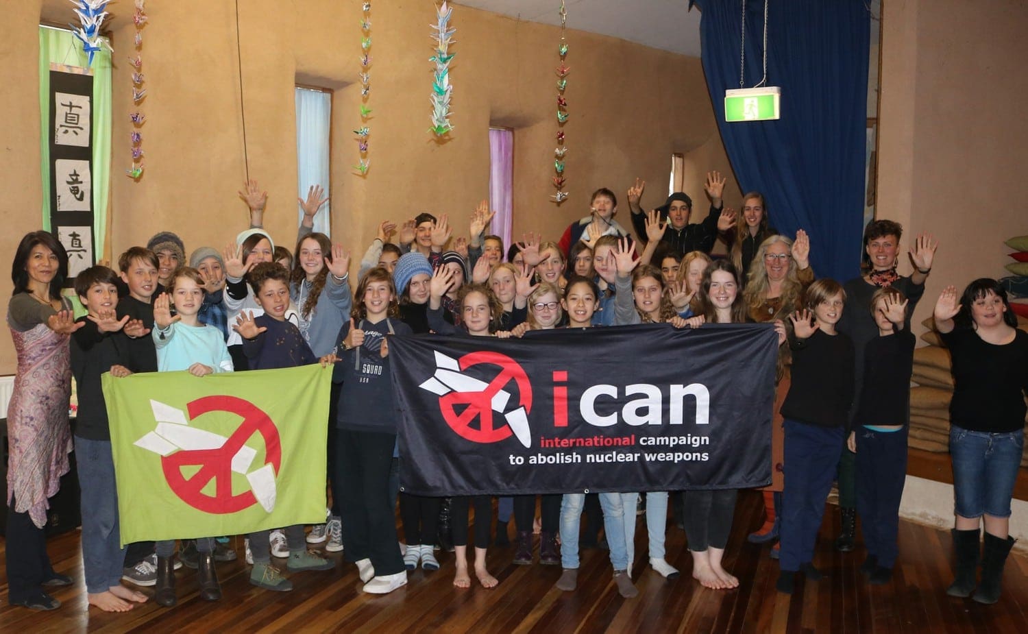 Kindlehill and Nagasaki students stand united with ICAN banners, fostering global peace and friendship through social action.