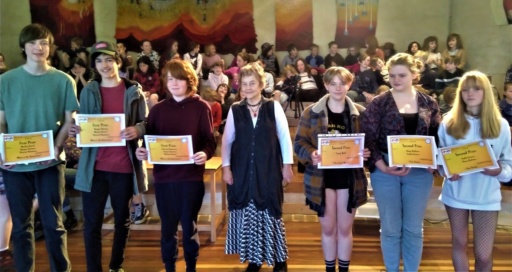 Empowered Kindlehill students display certificates for award-winning social justice films, embodying a culture of compassion and global awareness.