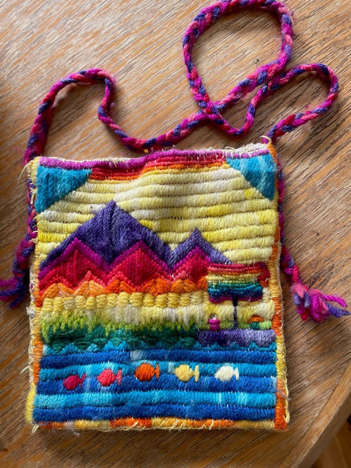 Hand-woven landscape pouch depicts mountains and lake, expressing a heart-centred connection to Country and tactile learning.