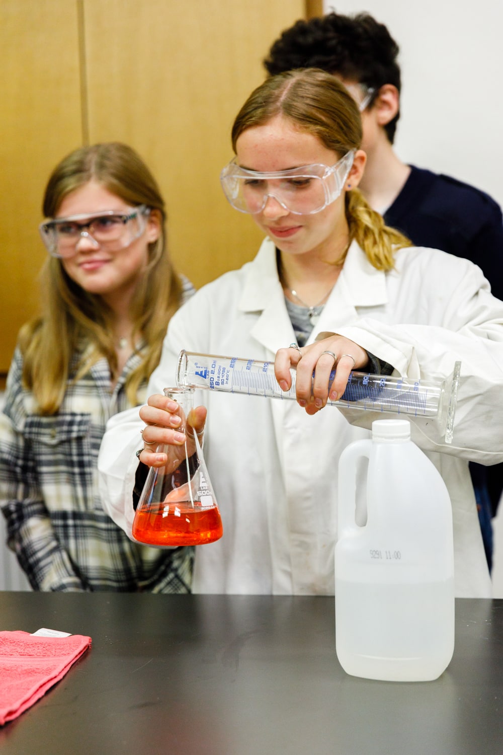Focused students collaborate on a chemistry experiment, transforming curiosity into a functional understanding of how the world works.