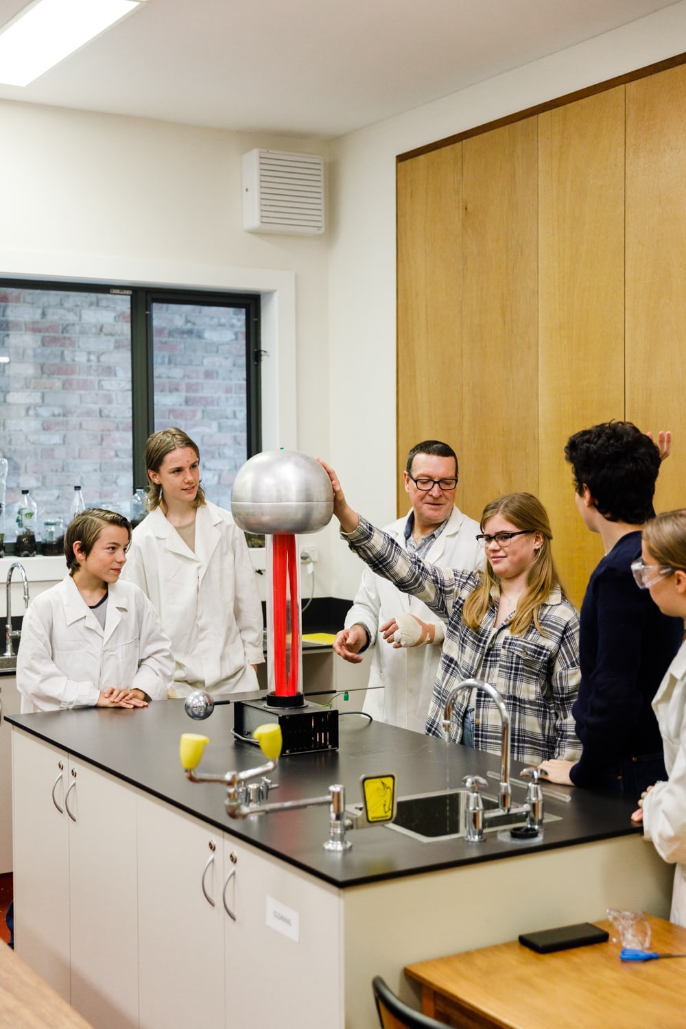 Students cultivate wonder through hands-on physics experiments, fostering scientific curiosity and holistic discovery within the laboratory.