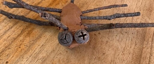 Handcrafted clay insect with gum nut eyes and twig legs expresses wonder and deep connection with the land.