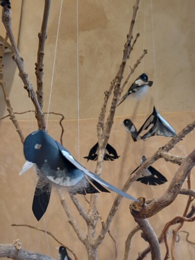 Handcrafted birds take flight from branches, symbolising the courage and freedom found within a childs unique learning journey.