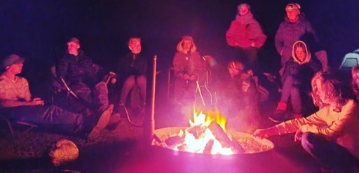 High school students share stories around a glowing winter solstice campfire, fostering deep community connection in the Newnes bushland.