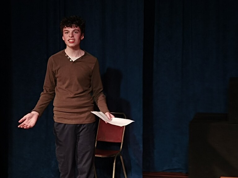 An empowered student delivers a monologue, honouring their unique voice through courageous performance and creative expression.