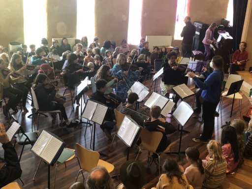 Kindlehill students and visitors unite through a collaborative orchestral workshop, harmonising together in a warm, musical community circle.