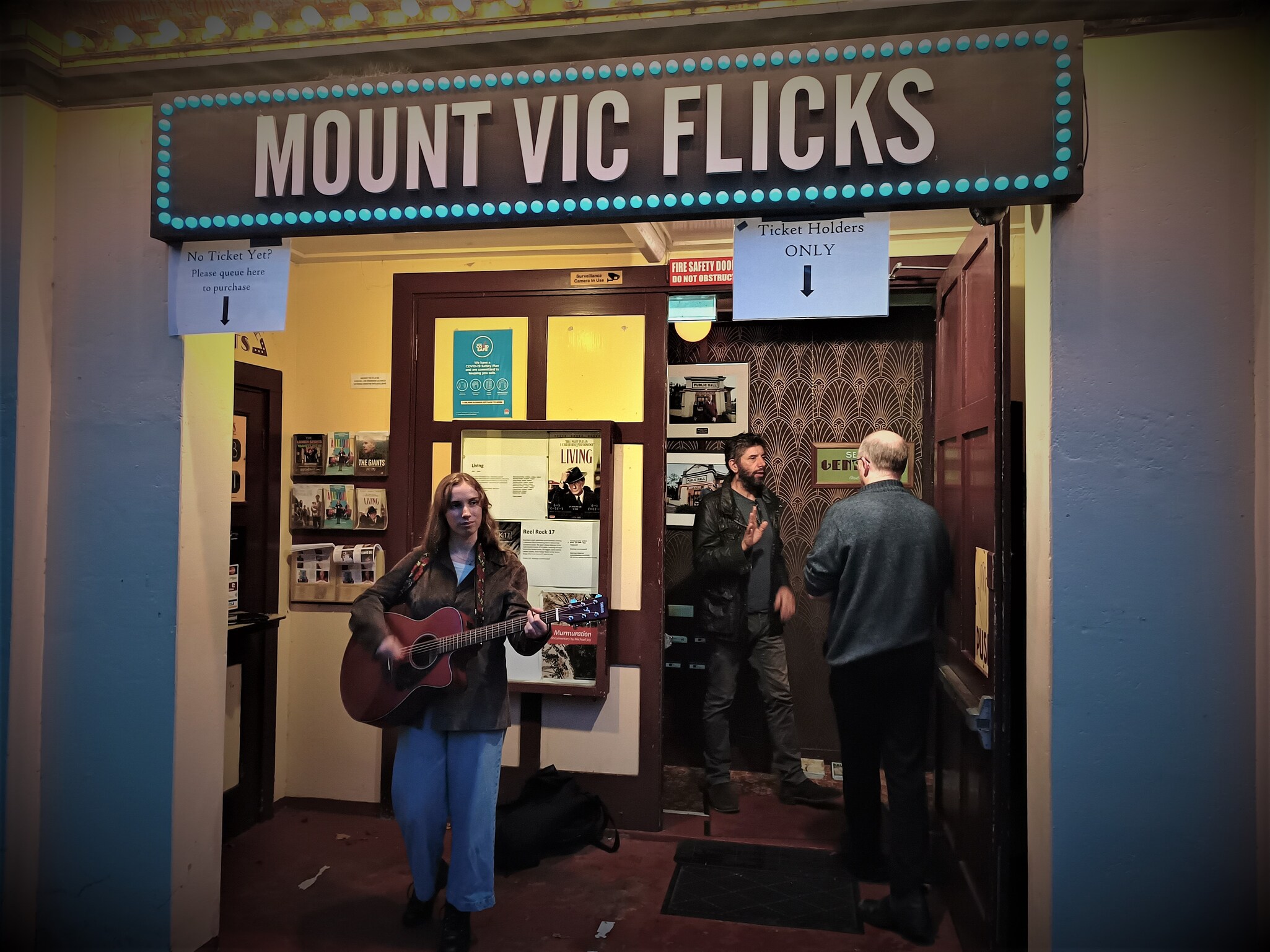 Kindlehill alumna performs music outside Mount Vic Flicks, fostering community connection and creative expression for the school launch.