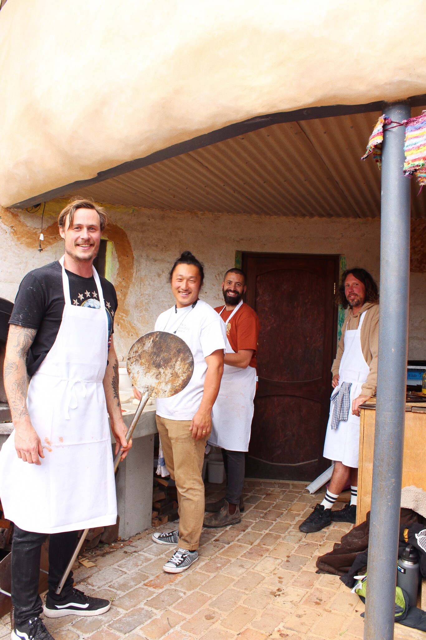 Smiling community members prepare food together, illustrating Kindlehills spirit of cooperation and shared contribution to the school village.