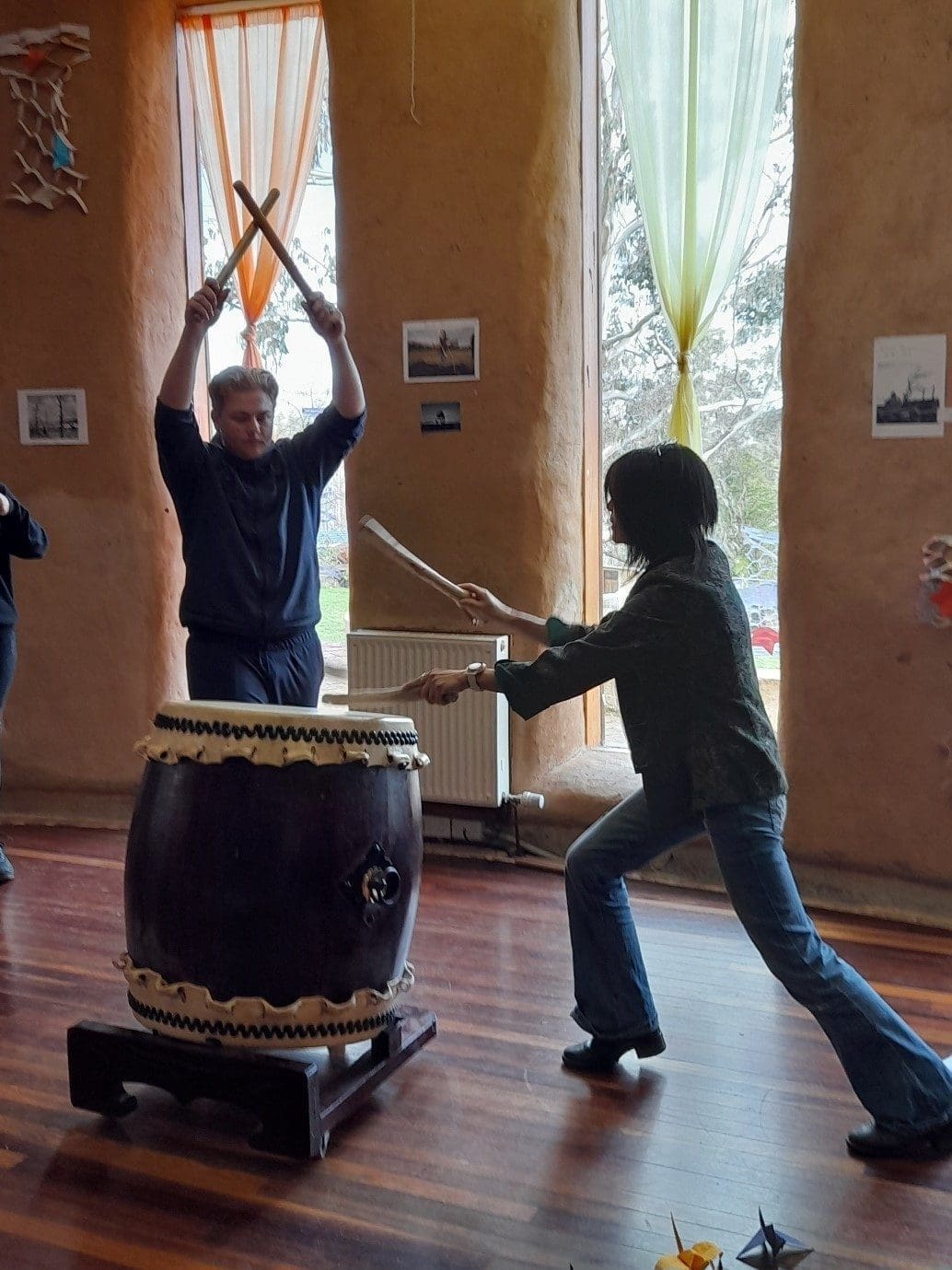 A student and guest perform Taiko drumming, honouring global peace through rhythmic connection and heart-centred community expression.