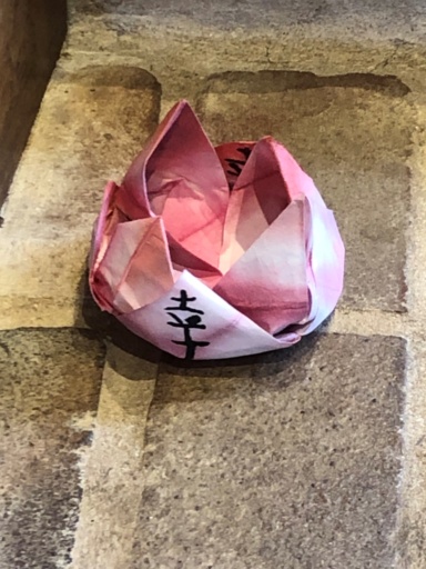 Hand-folded pink origami blossom honouring Hiroshima remembrance through beauty, reflecting Kindlehills commitment to global peace and compassion.