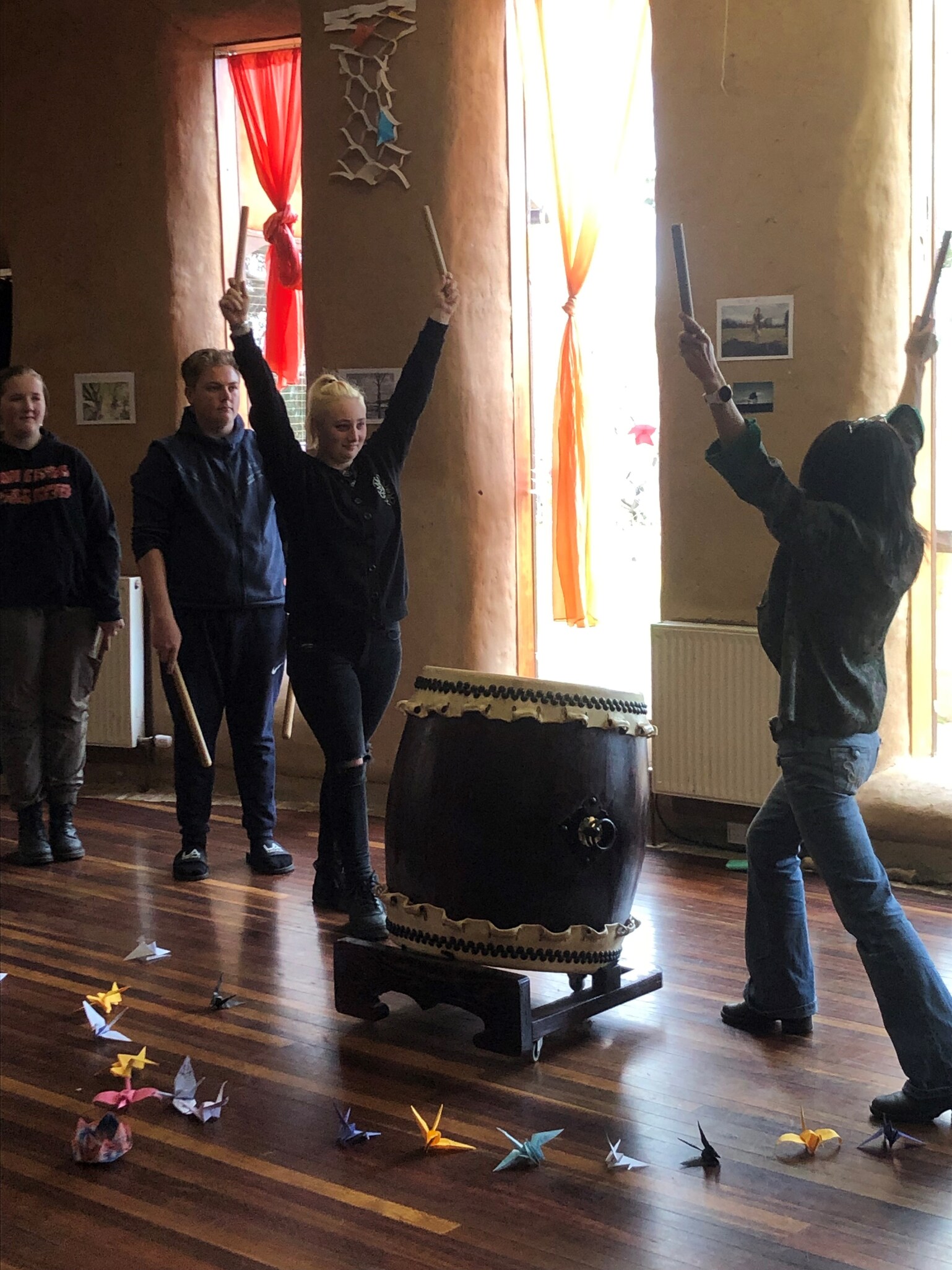 Sayoko and Class 10 students honour peace through Taiko drumming, surrounded by paper cranes in the Kindlehill hall.
