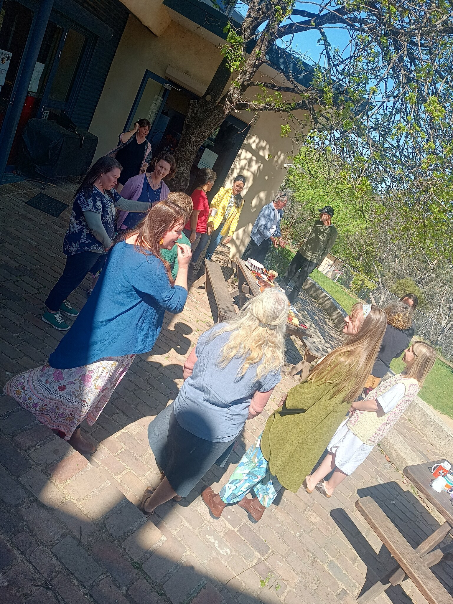 Kindlehill community members gather outdoors for a reverent smoking ceremony, grounding their collaborative and culturally nourishing school visions.