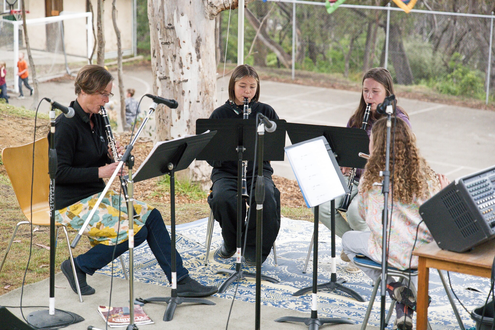 Musicians perform together outdoors, re-threading hearts with beauty and wonder through shared melodies and community spirit.