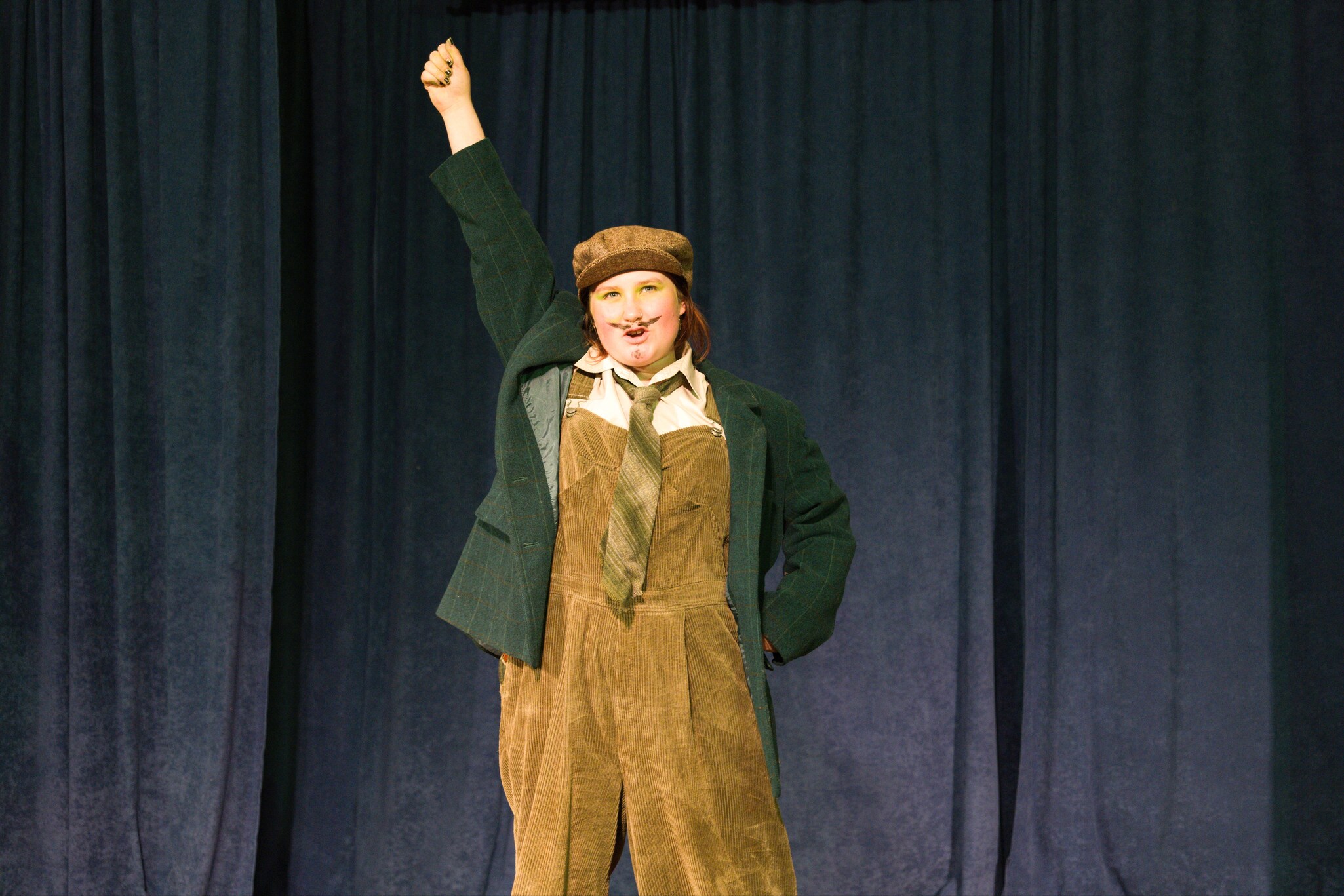 A student performs triumphantly on stage, showcasing the courage and imagination nurtured through Kindlehills heart-centred theatrical journey.
