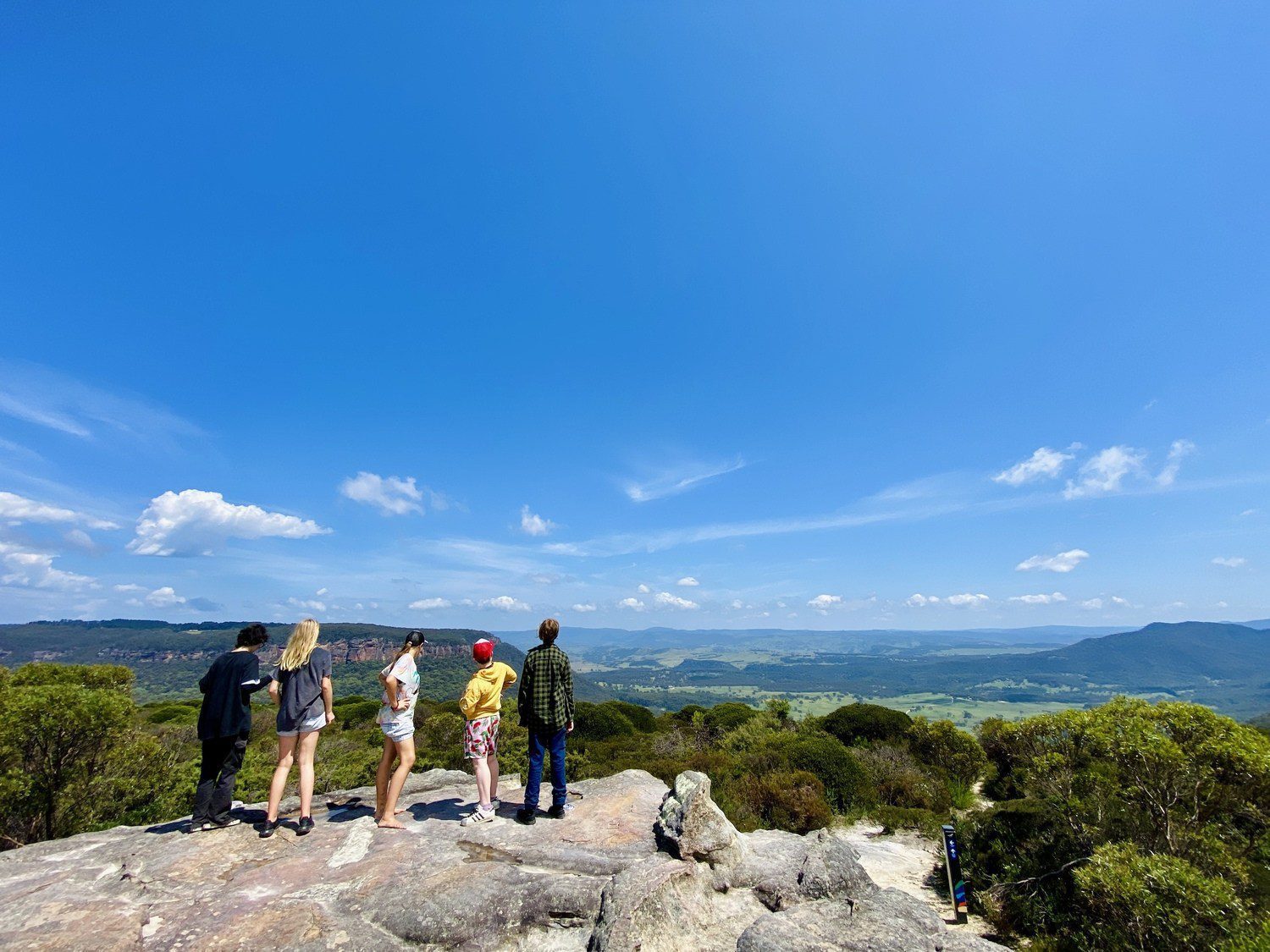 low-vision users need to know they are students and what they are looking at. Lets go with: Kindlehill students stand united on a rocky summit, gazing across the vast, wild valleys