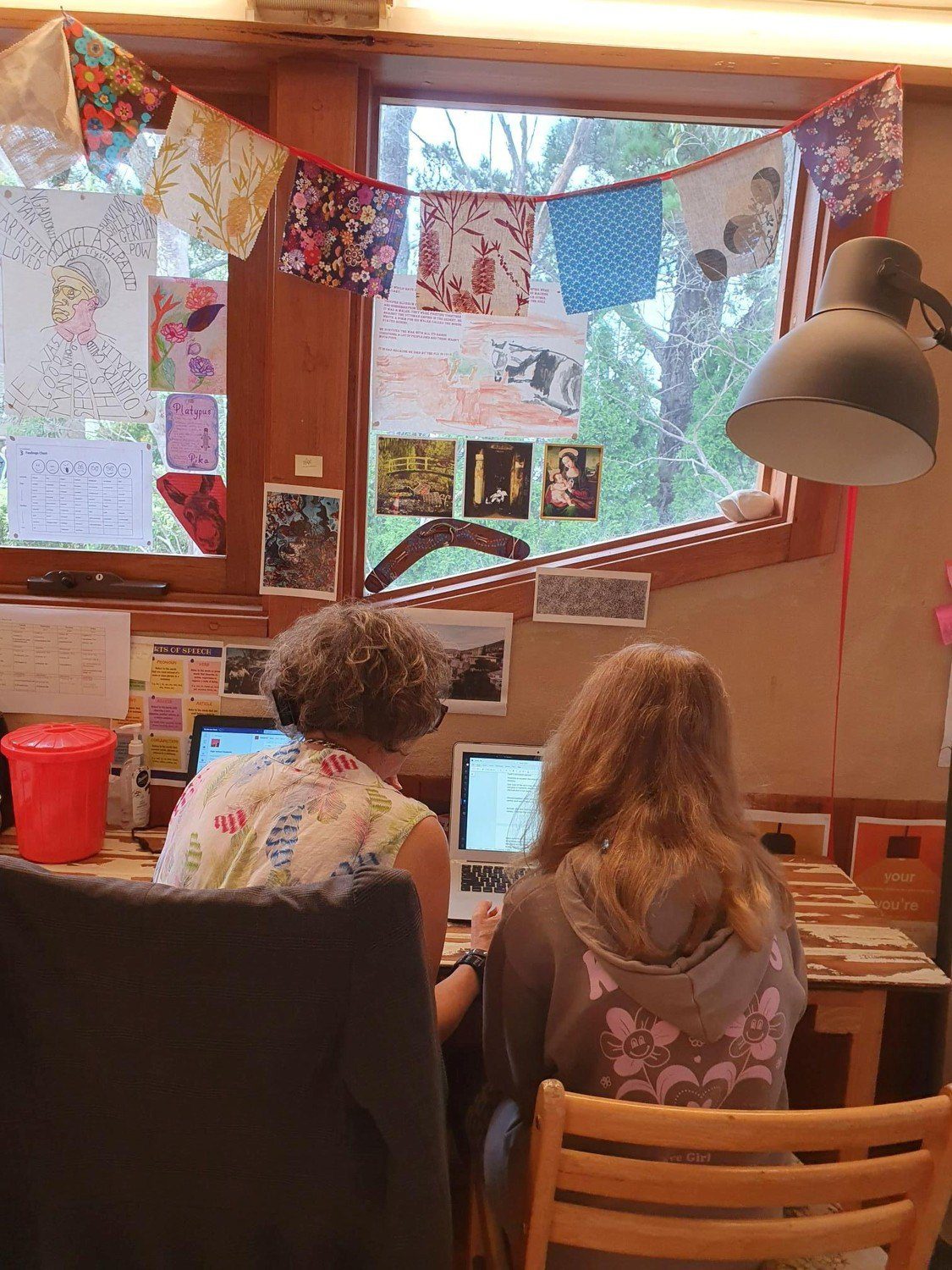 Student and mentor collaborate on an individualised learning journey, reflecting together within a warm, bushland-connected classroom hearth.