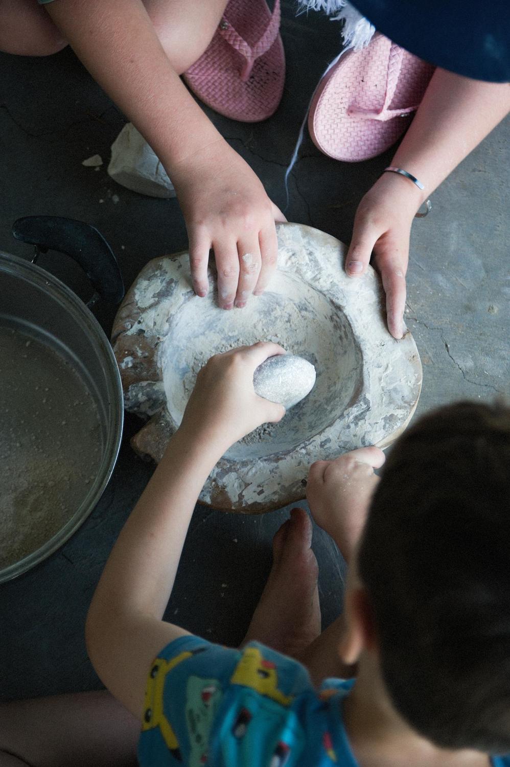 Children collaboratively grind white ochre, honouring First Nations stories and fostering a deep, shared connection to Country.