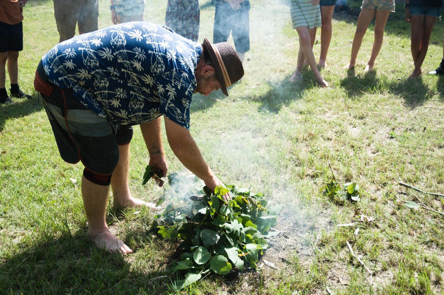 Parents and children participate in a smoking ceremony, honouring First Peoples stories and connecting to Country on camp.