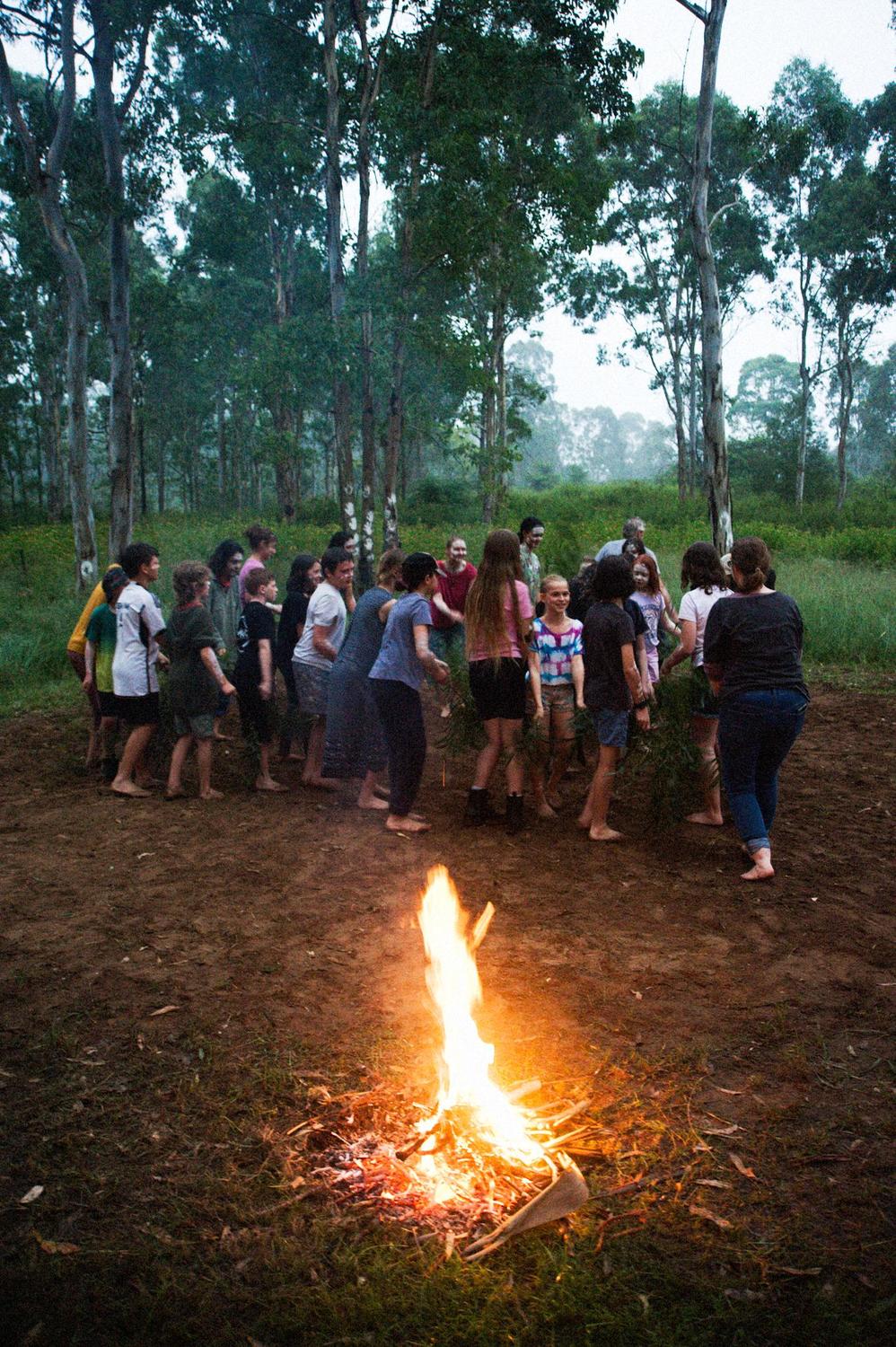 Kindlehill students and parents honour Country through song and ceremony around a bush campfire during school camp.