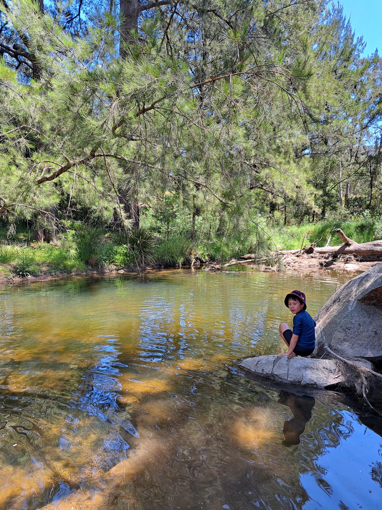 A Kindlehill student sits on a rock by Coxs River, discovering the natural beauty and stories of Country.
