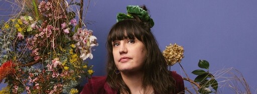 Native Australian flowers surround a woman, expressing Kindlehills earth-centred connection to Country and artistic spirit.