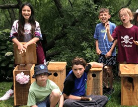 Smiling students showcase handcrafted timber nesting boxes, uniting purposeful woodwork with a deep connection to local birdlife.
