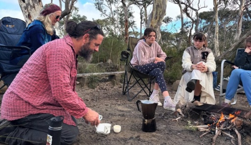Uncle Chris Tobin shares stories with Kindlehill students around a bush campfire, honouring deep connection to Country.