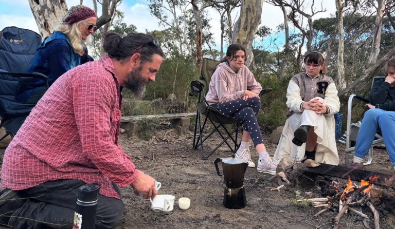 Uncle Chris Tobin shares stories with Kindlehill students around a bush campfire, honouring deep connection to Country.