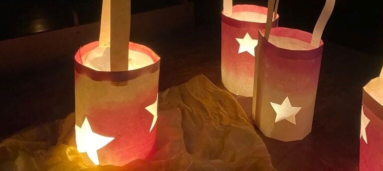 Handmade paper lanterns glow with stars, symbolising the light and connection within the Kindlehill communitys winter celebration.