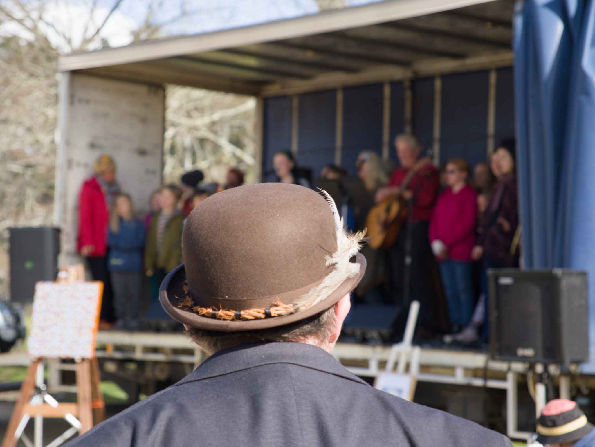 The Kindlehill community sings together on stage, celebrating their shared spirit and connection during a winter gathering.