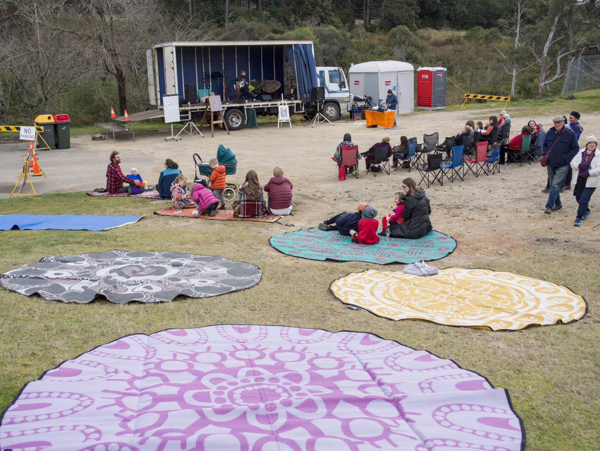 Kindlehill families gather on patterned mats for music and connection, honouring Country and community at the Ganya.