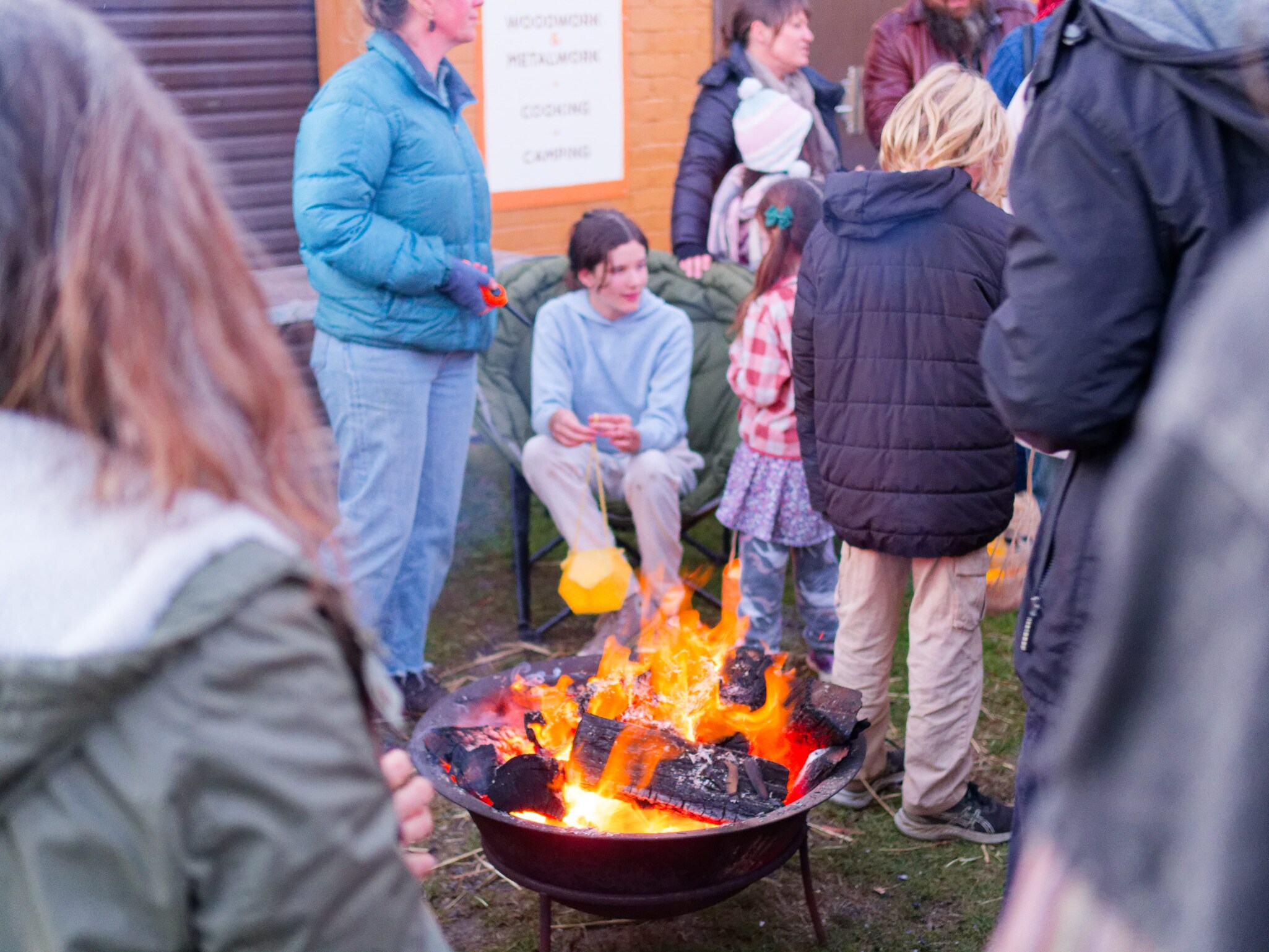 Community members gather around a glowing fire pit, sharing light and warmth during a winter ritual of hope.