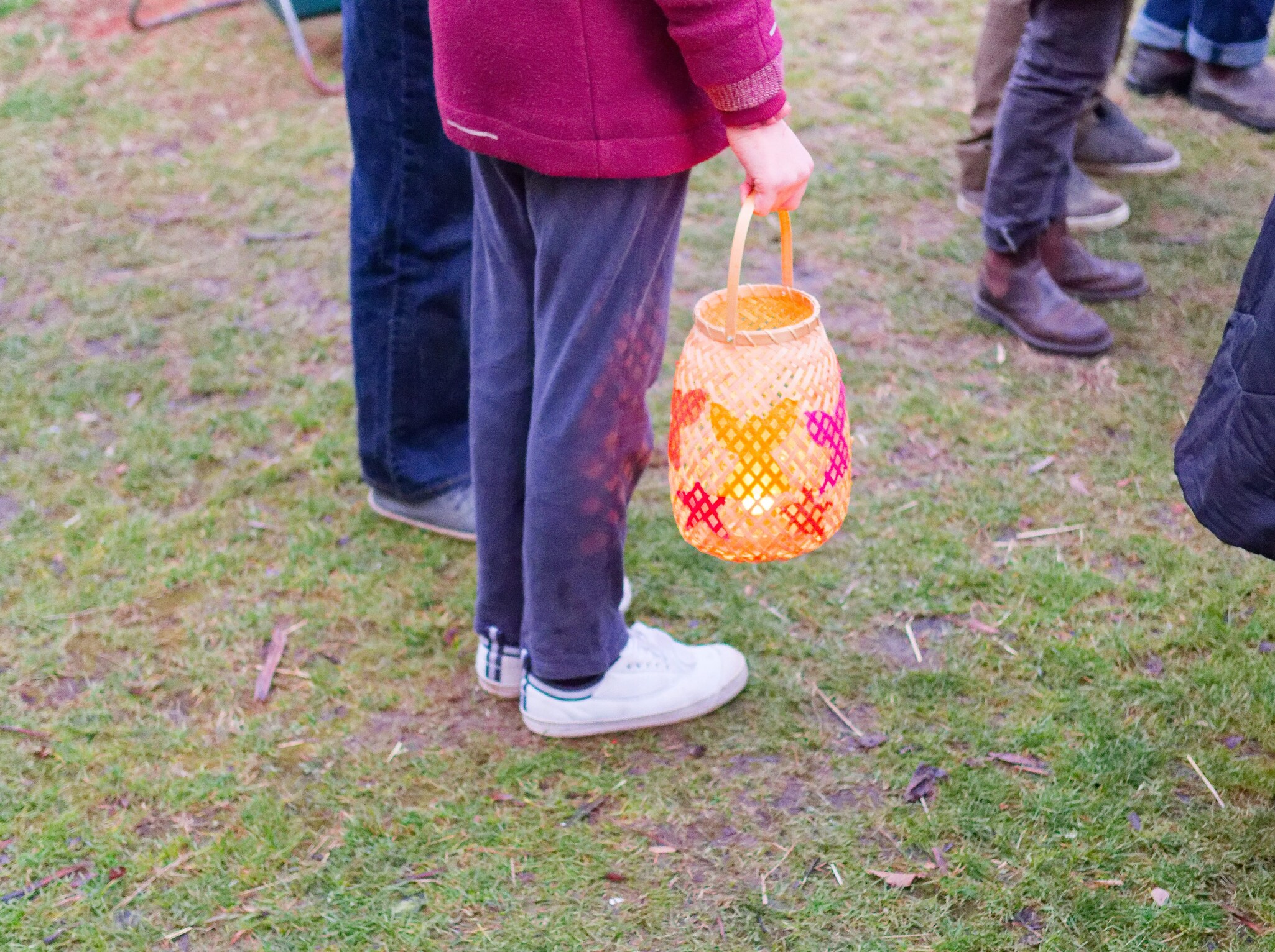 A child carries a colourful lantern, sharing a ritual of hope and light during Kindlehills communal winter celebration.