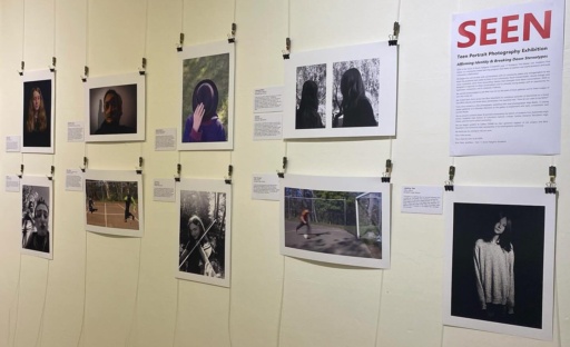 Emotive photography portraits celebrating teen identity and creative expression hang displayed at a local community gallery exhibition.