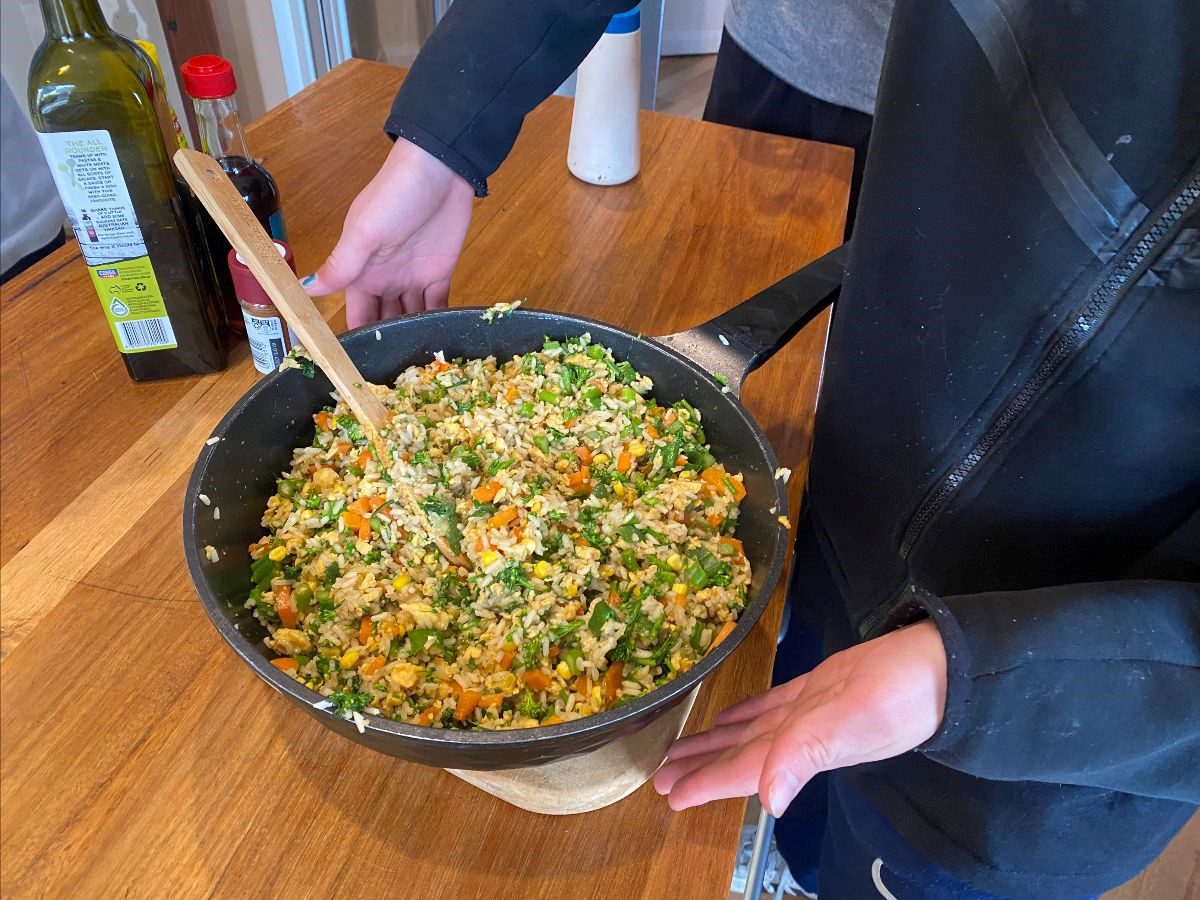 Students prepare a nourishing vegetable meal, cultivating connection and community through the heart of shared contribution and compassion.