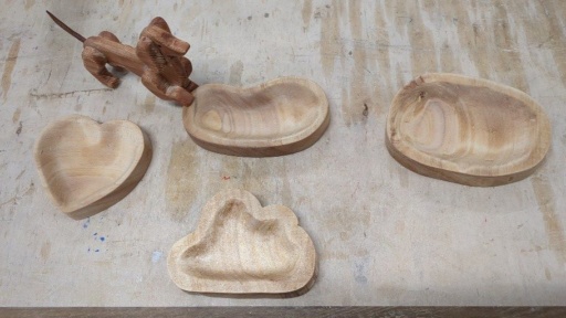 Hand-carved timber vessels and a sculpted dog showcase organic craftsmanship and the creative harmony of head, heart, and hands.