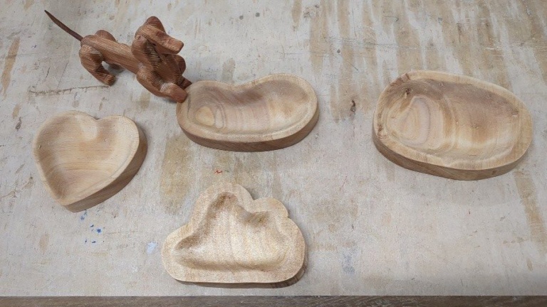 Hand-carved timber vessels and a sculpted dog showcase organic craftsmanship and the creative harmony of head, heart, and hands.